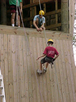 Alex Thompson rappelling down the climbing wall.